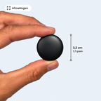 De tracker tussen duim en wijsvinger, met de maat erbij: 3,2 centimeter doorsnede en 7,7 gram