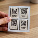 Een hand houdt een vel met vier terugvindstickers vast boven een houten bureau